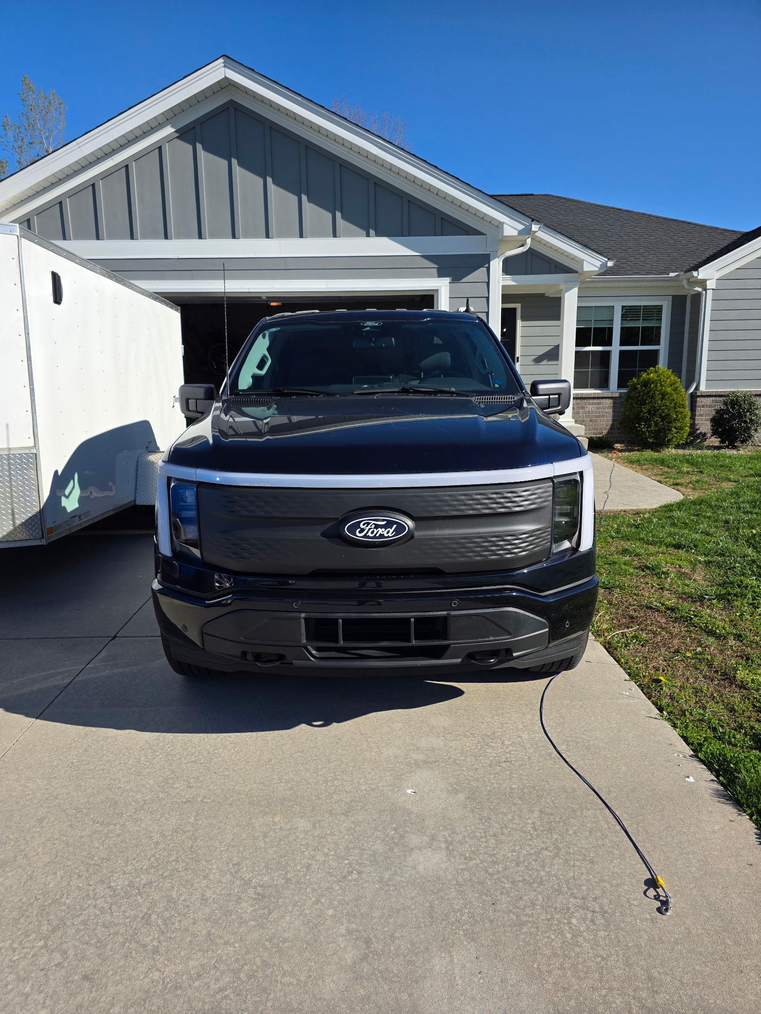 Henry Brothers HVAC Ford F-150 Lightning truck front view at residential customer home driveway