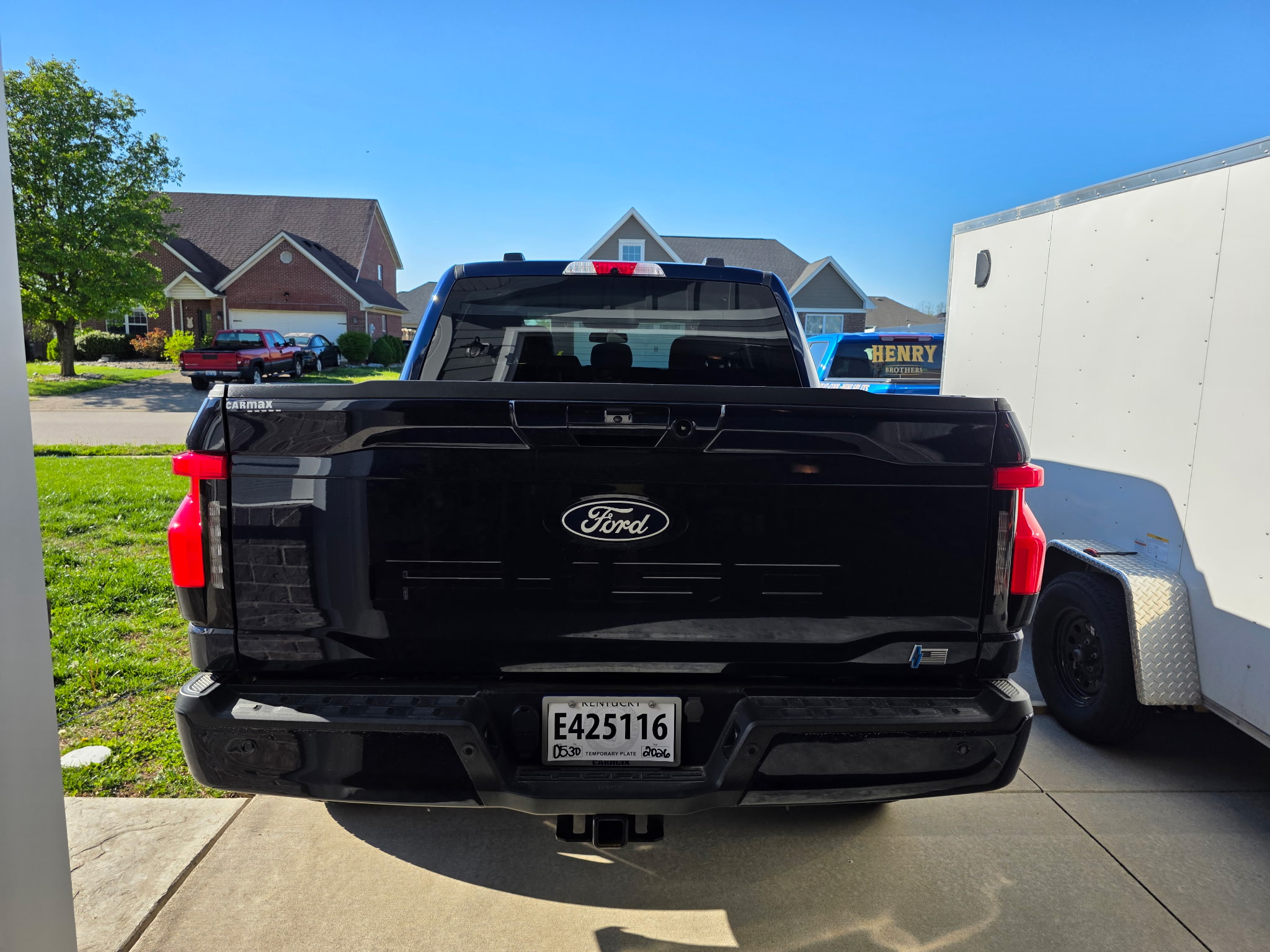 Rear view of Ford truck with Henry Brothers branded service van visible in background at job site