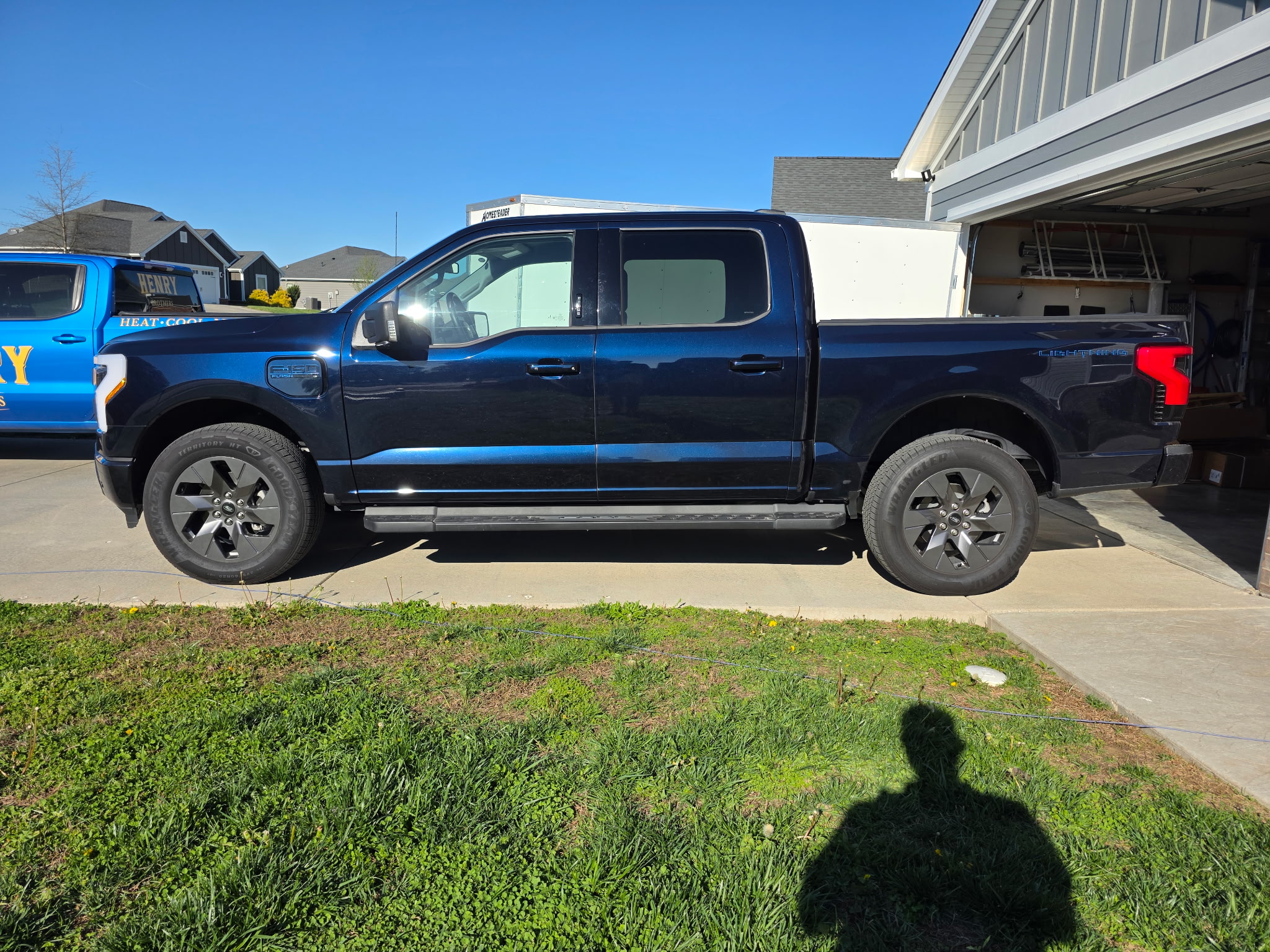 Henry Brothers branded service truck Ford F-150 Lightning parked at residential job site