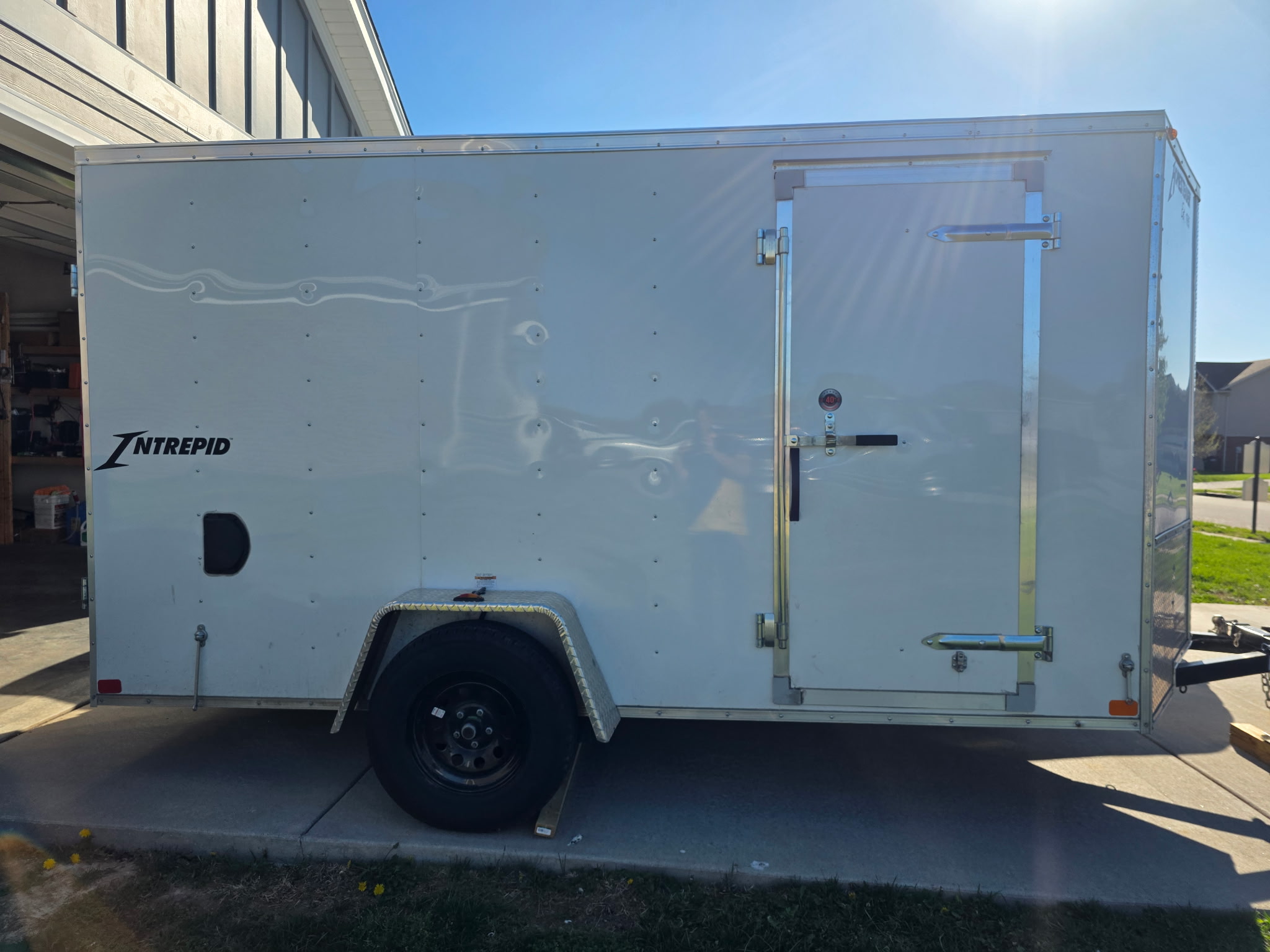 Henry Brothers HVAC white Intrepid enclosed work trailer parked at technician home base