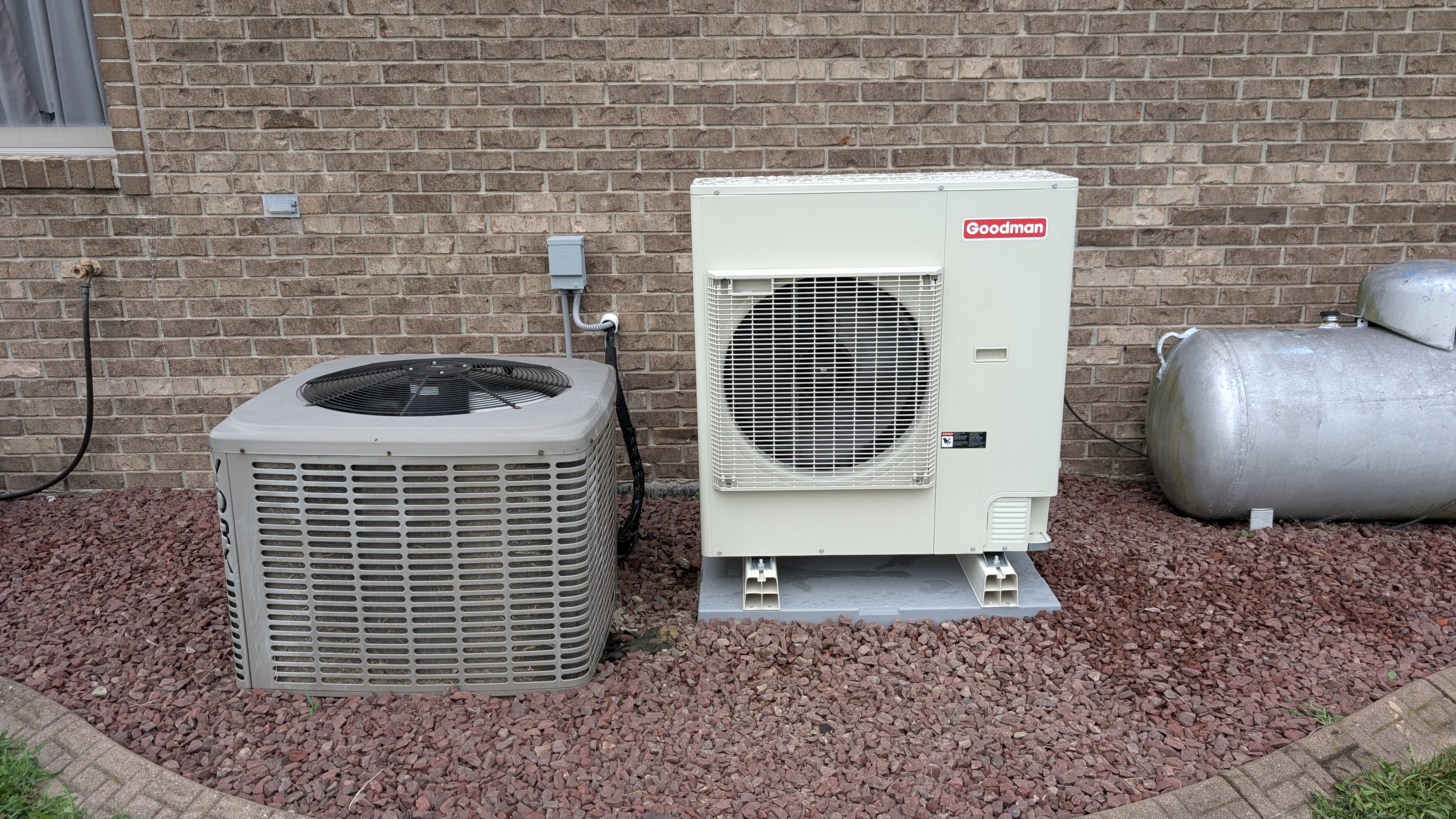 Side-by-side old York central AC and new Goodman mini-split condenser installed Clark County Indiana