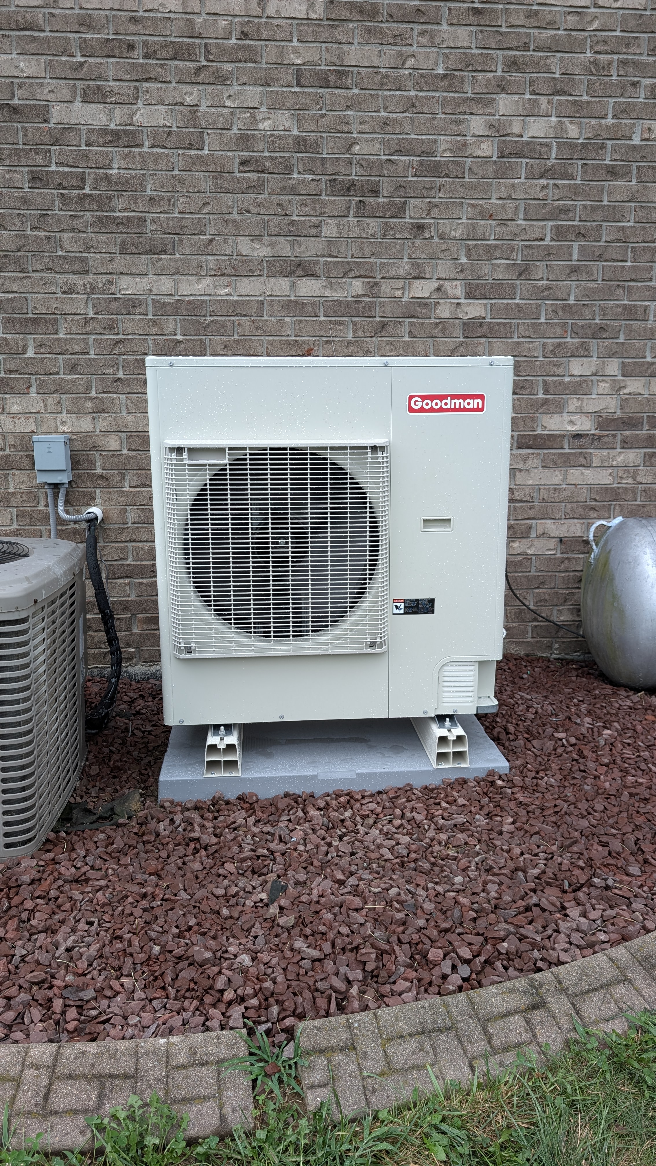 Installed Goodman mini-split condenser on pad with propane tank and old AC unit Clark County Indiana