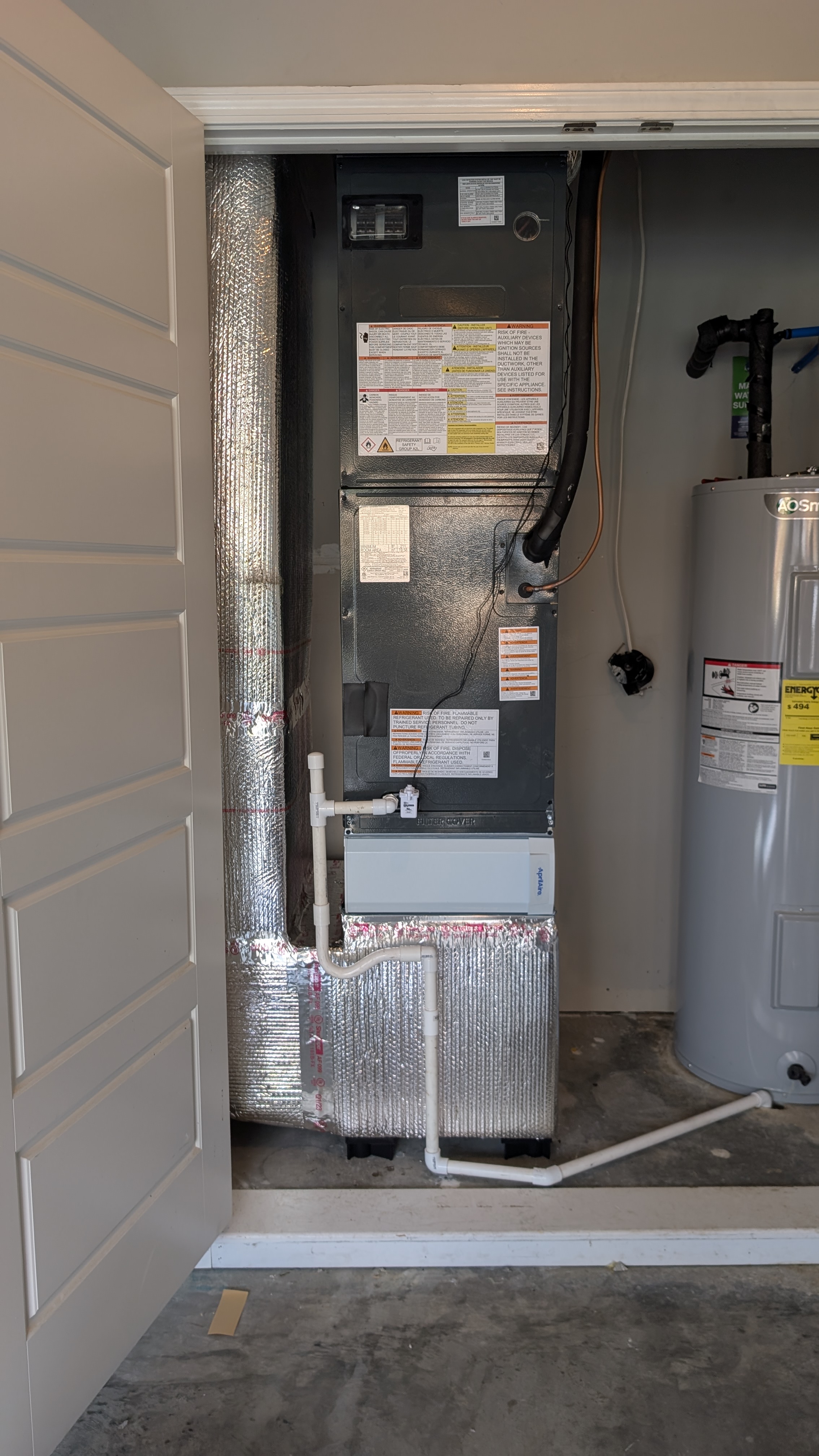 Newly installed air handler, Aprilaire filter cabinet and evaporator coil in a garage closet beside an AO Smith water heater, Clark County Indiana