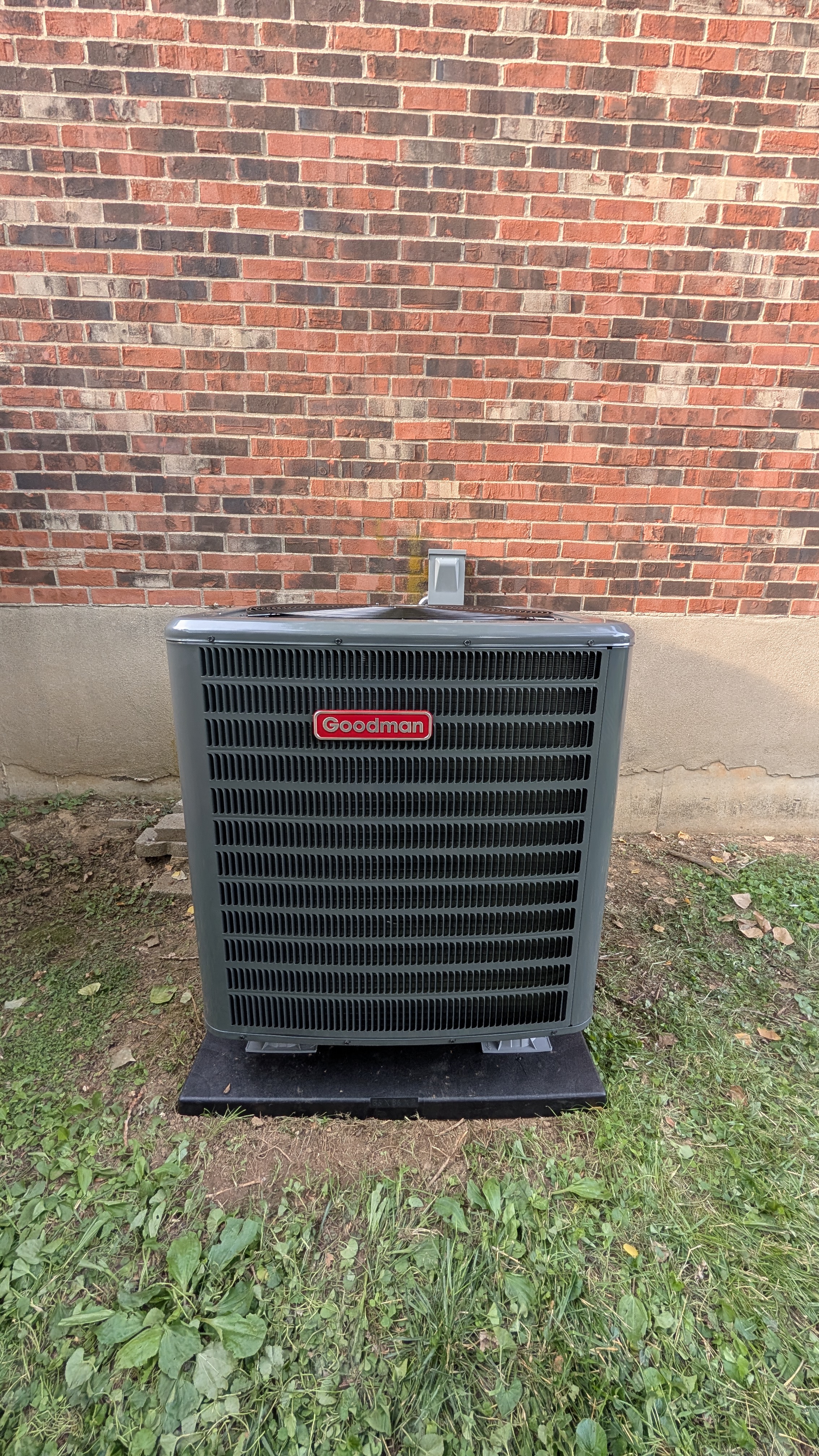 Aging Goodman AC condenser side view showing wear before HVAC replacement