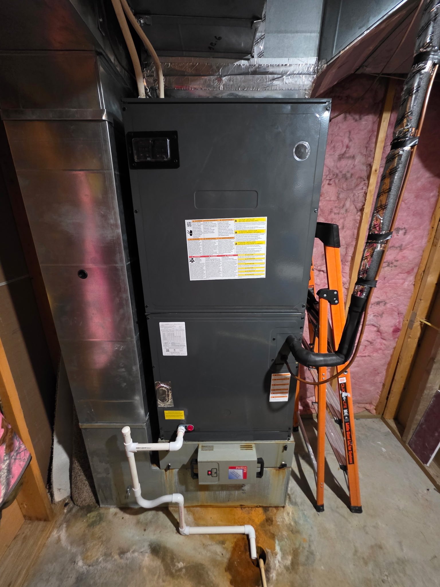 Air handler unit in unfinished basement with ladder and refrigerant line visible during inspection