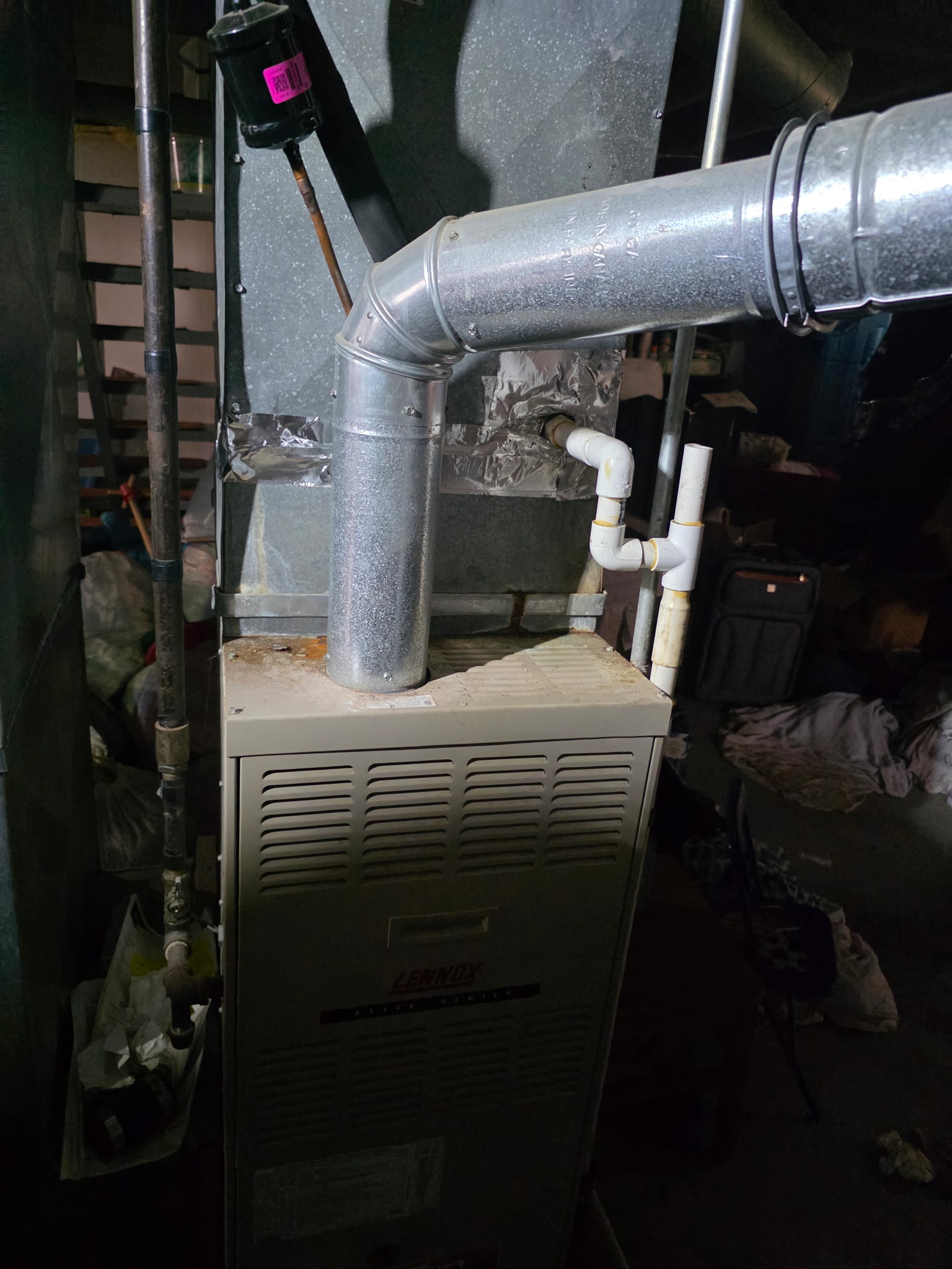 Lennox furnace ductwork and flue pipe in older basement during HVAC system assessment
