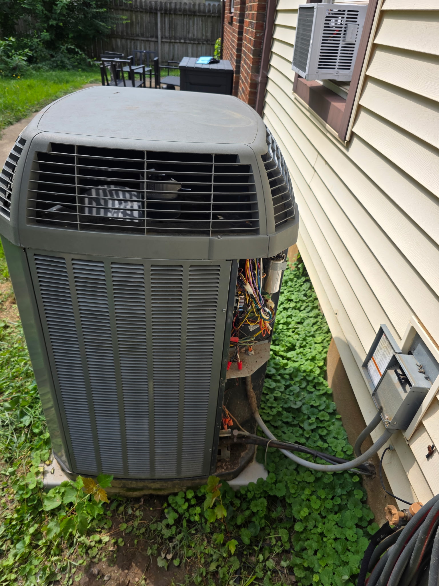 Trane central AC condenser with the electrical access panel removed, exposing the capacitor and control wiring during a second opinion inspection