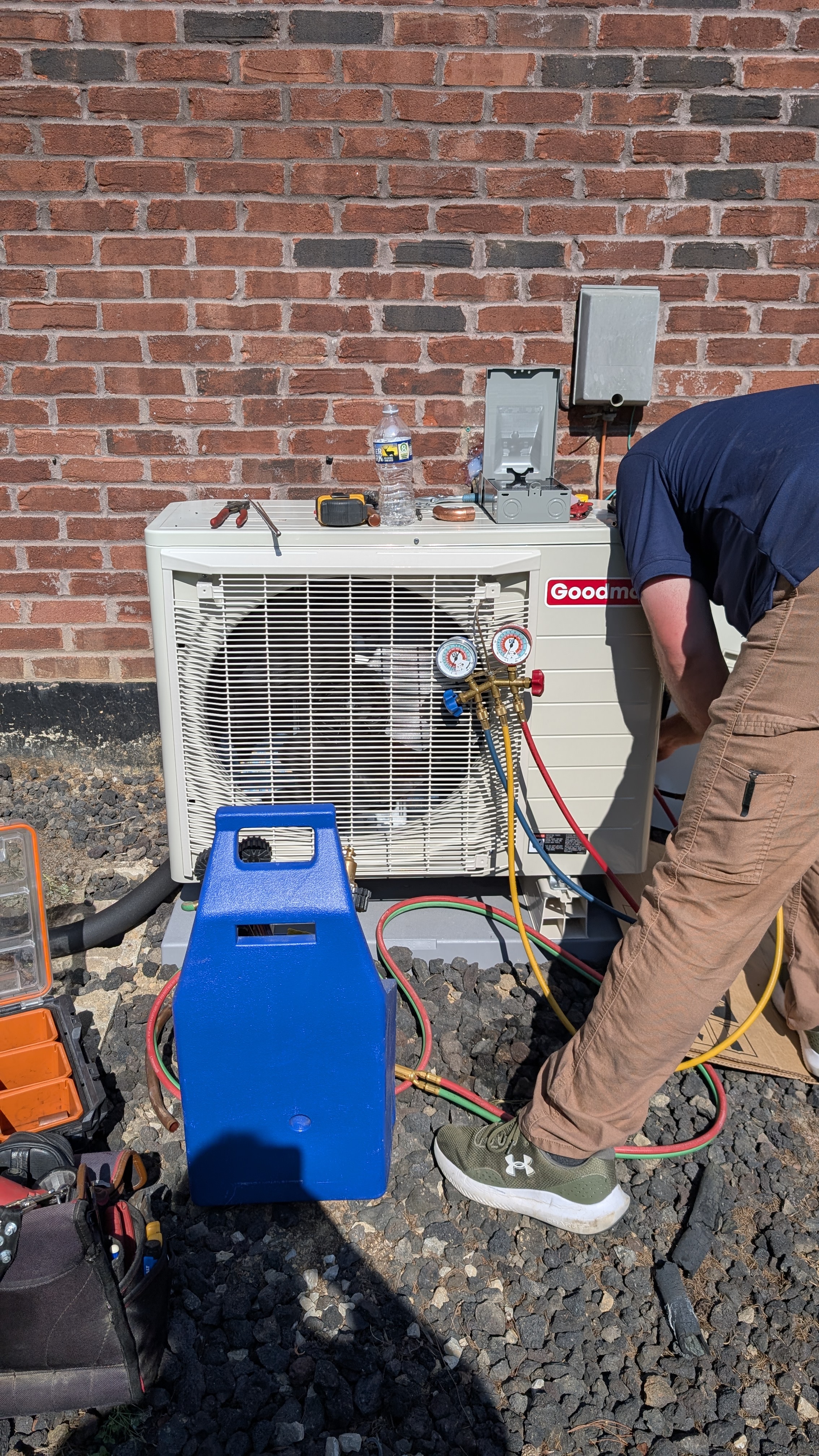 Technician charging Goodman mini-split outdoor condenser with refrigerant gauges Memphis Indiana