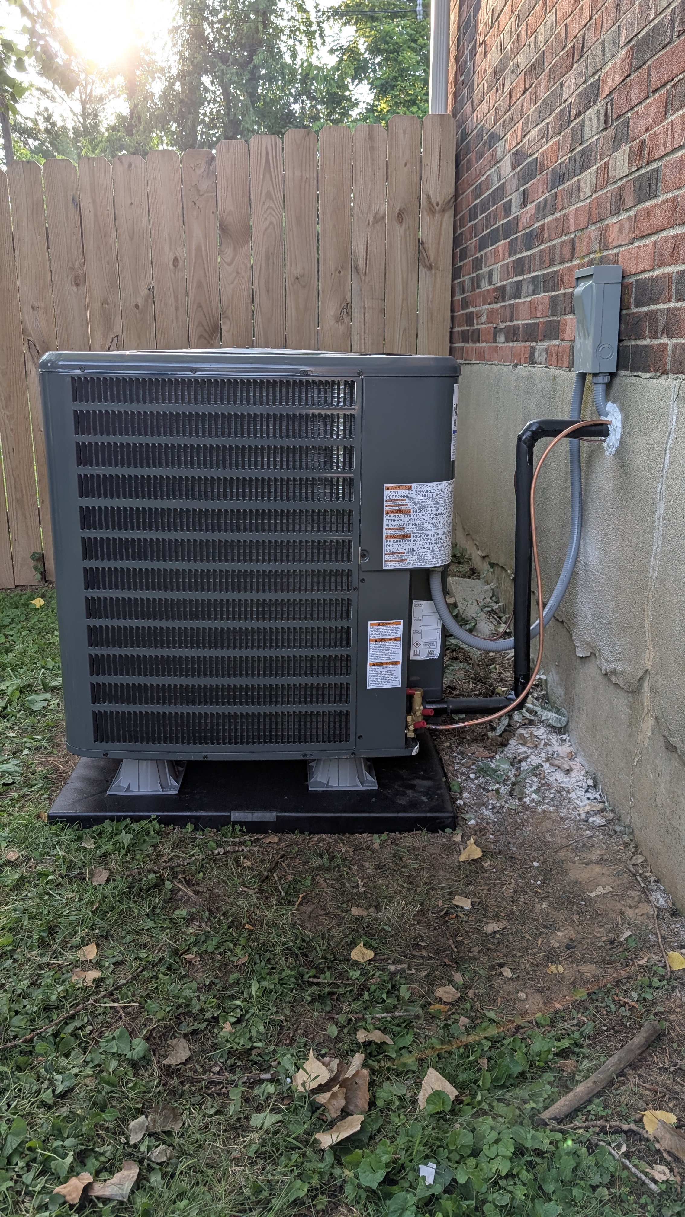 New Daikin condenser side angle showing line-set routing to wall disconnect