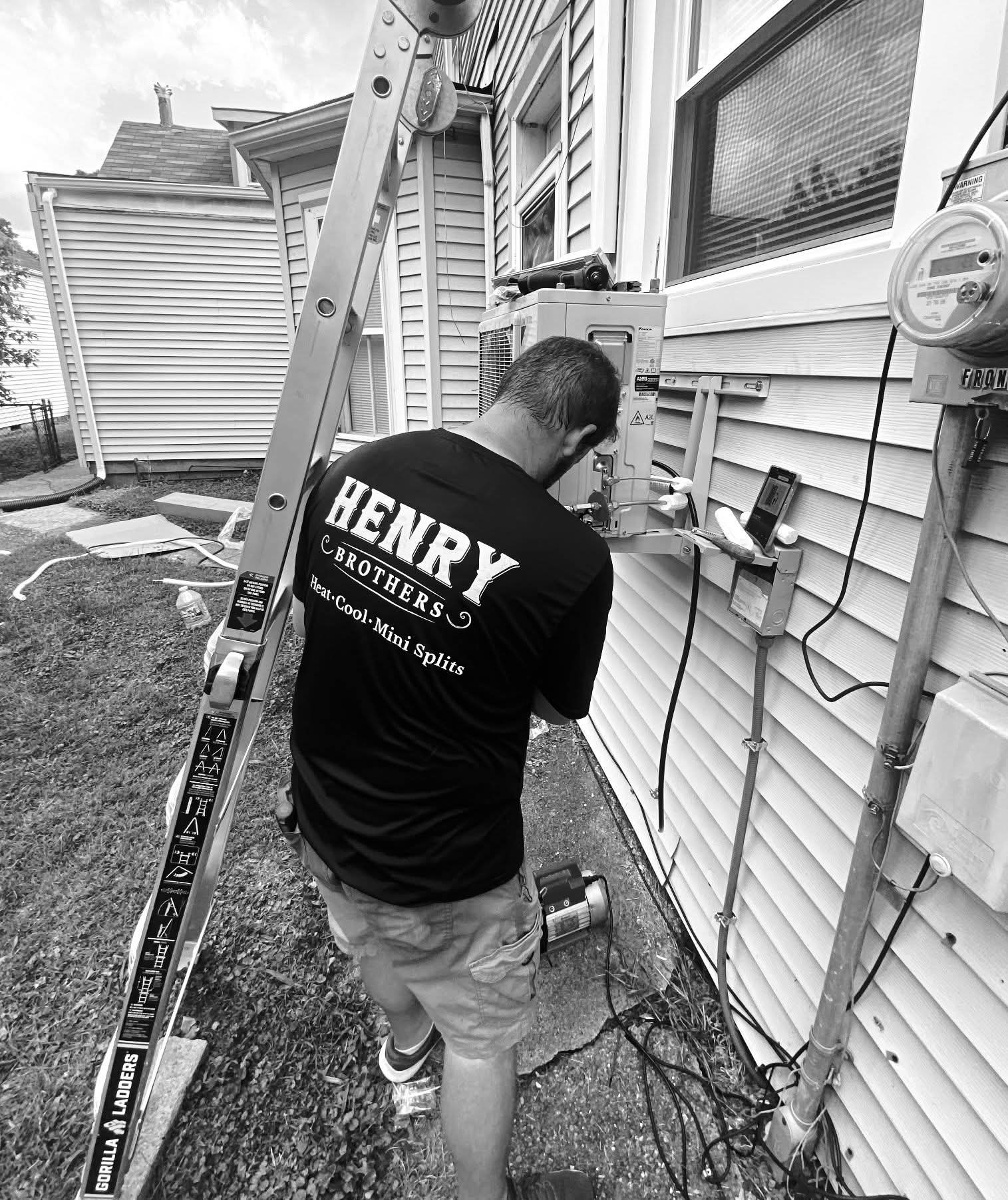 Henry Brothers technician running line set on home exterior during mini-split installation