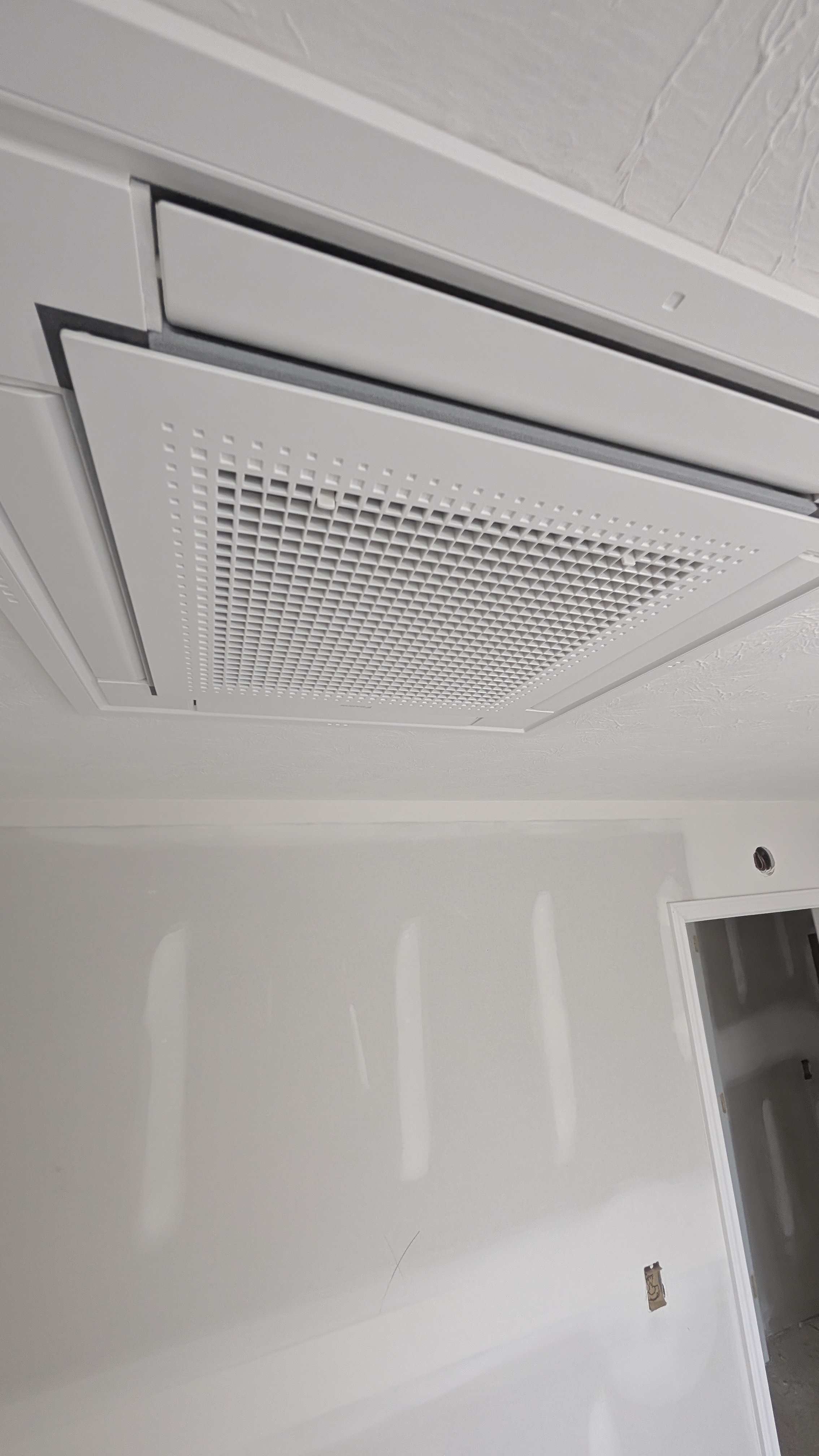 Finished ceiling cassette mini-split indoor unit flush-mounted in drywall ceiling installation