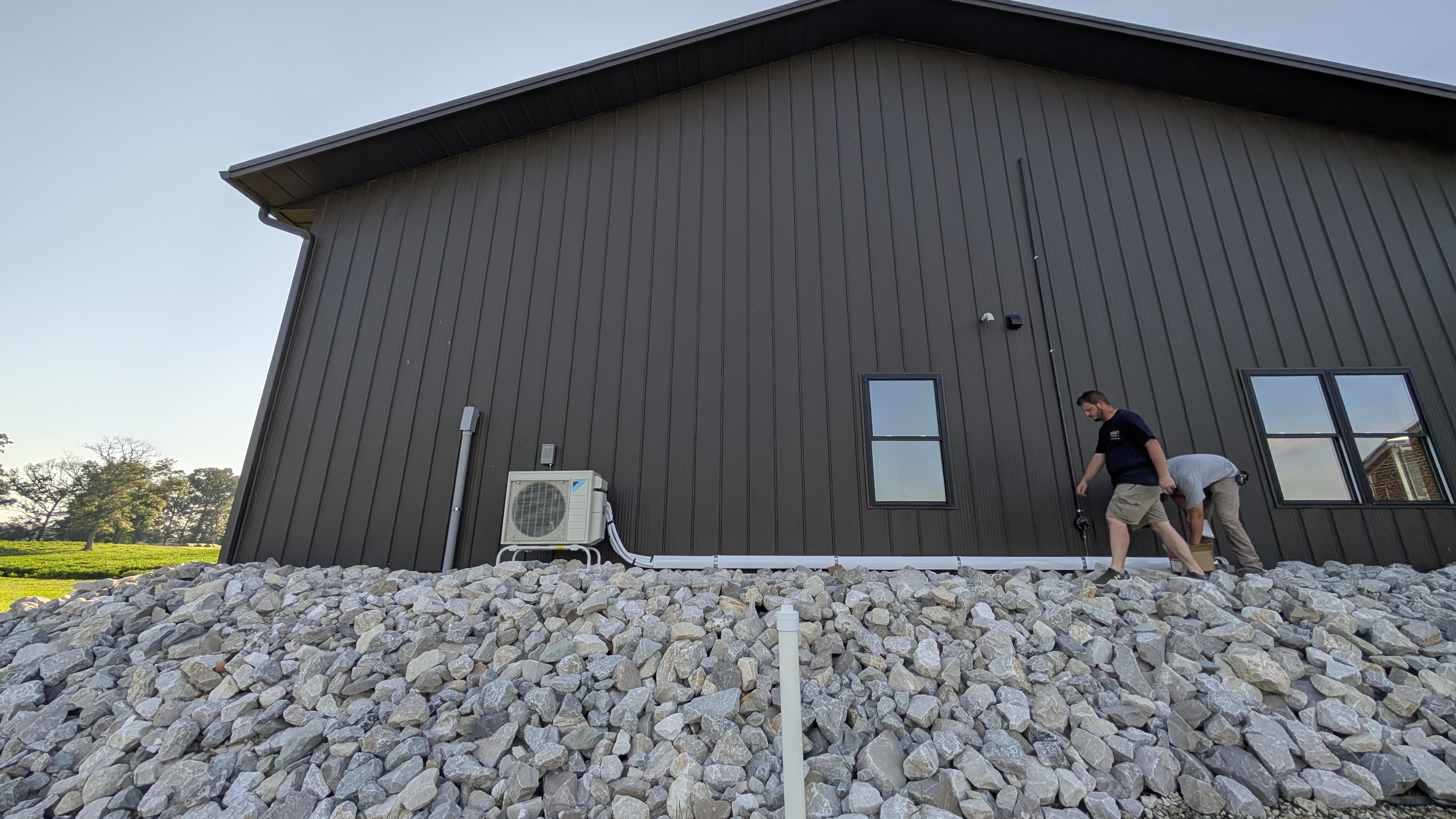 Henry Brothers team finishing Daikin mini-split install on large dark metal barn Washington County Indiana