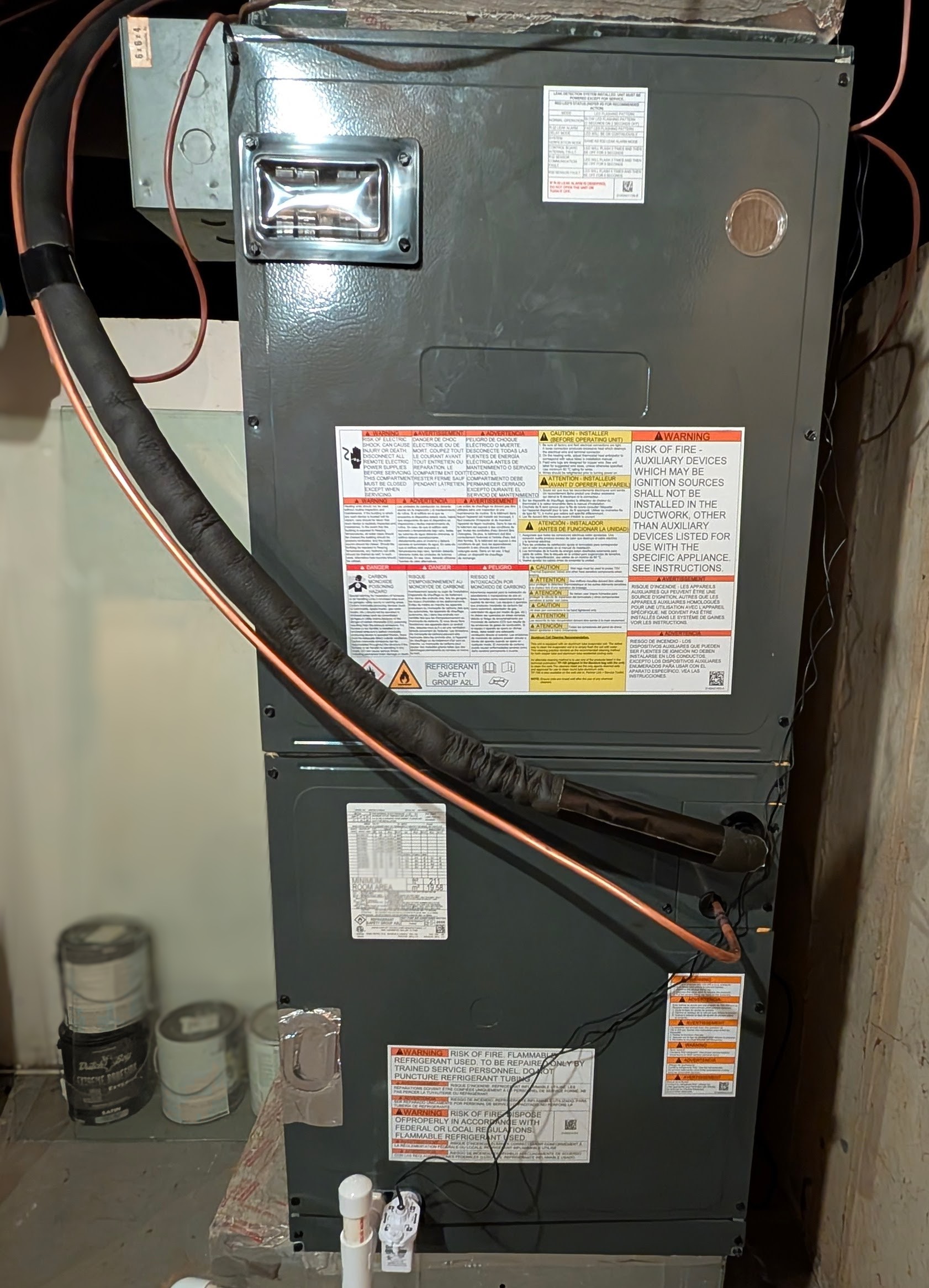 Mini-split air handler in basement utility room with copper refrigerant line set connection