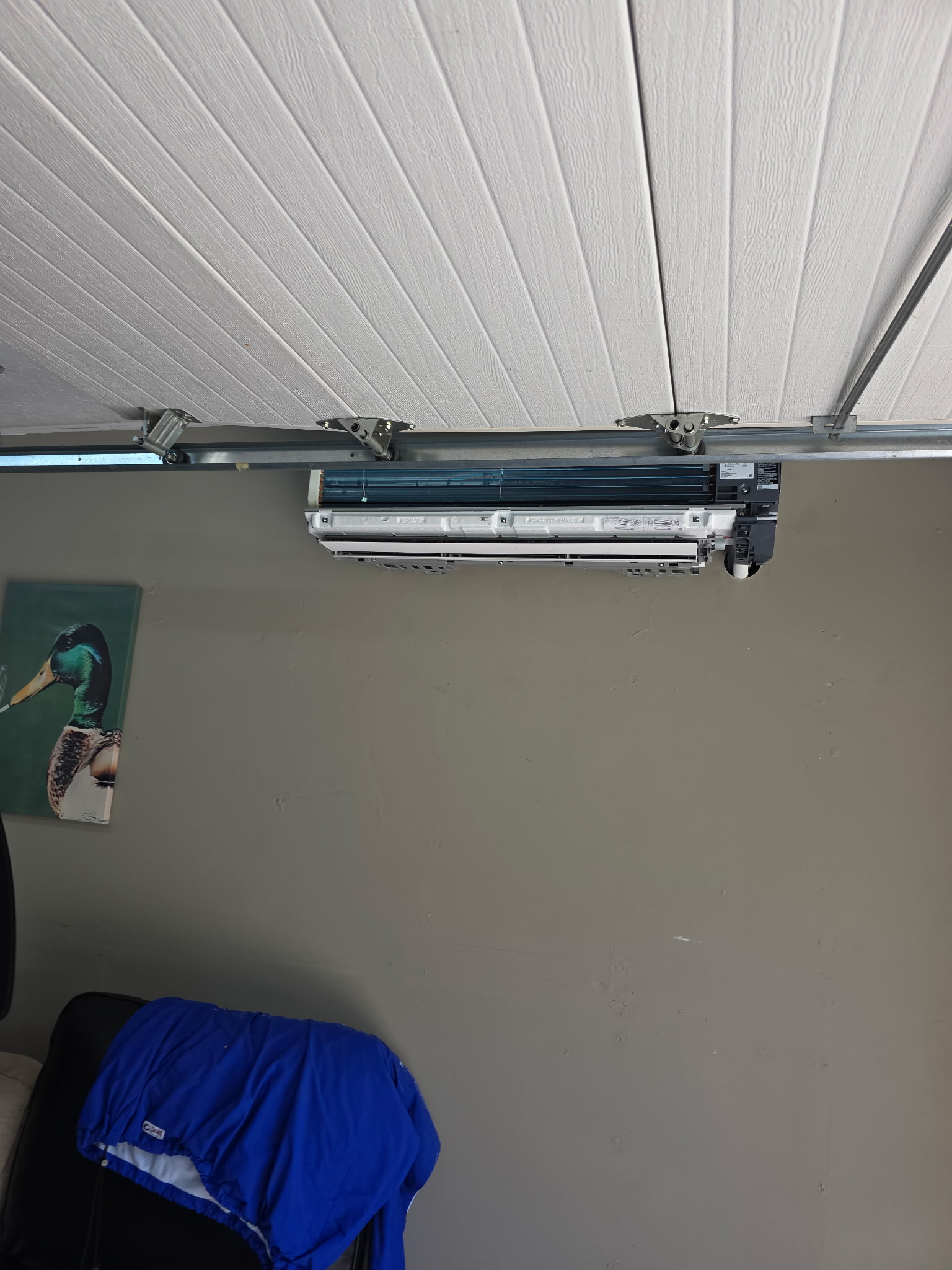 Mini-split indoor unit open for installation mounted on garage wall track bracket